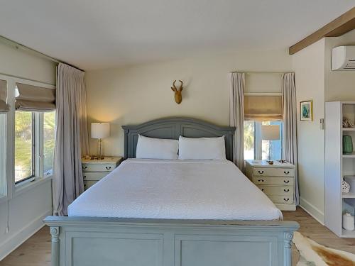 a bedroom with a large bed and two windows at Soundside in Pensacola Beach