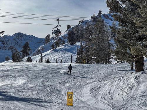 a person skiing down a snow covered slope with a ski lift at Powder Mtn Chalet B4 Ski Escape Hot Tub & View in Eden