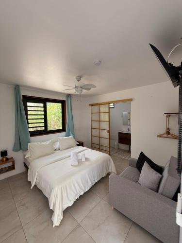 a bedroom with a large bed and a couch at MOOREA CHILL and BEACH LODGE in Teavaro
