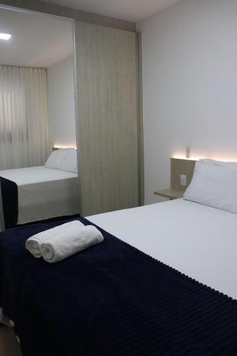 a hotel room with two beds with towels on the bed at Design e Amor no Centro in Palmas