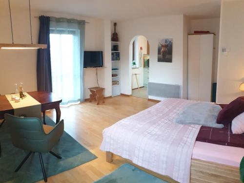 a bedroom with a bed and a desk and a chair at Frisch renoviertes BergSeeNest in Bad Bayersoien