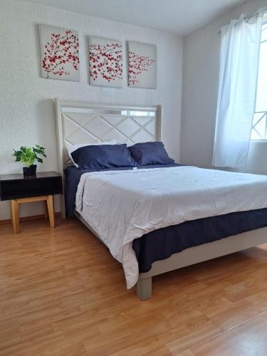 a bedroom with a bed and a table and a window at Hermoso departamento cómodo in San Lorenzo Tetlixtac