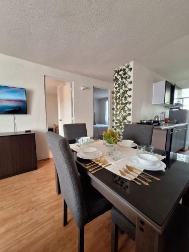 a dining room table with chairs and a kitchen at Hermoso departamento cómodo in San Lorenzo Tetlixtac