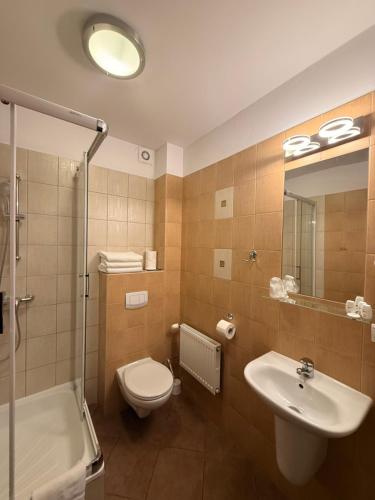 a bathroom with a toilet and a sink and a shower at Hotel Gryf in Kościerzyna