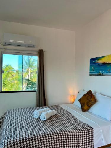 a bedroom with a bed with two towels on it at Casa da Juma in Fortim