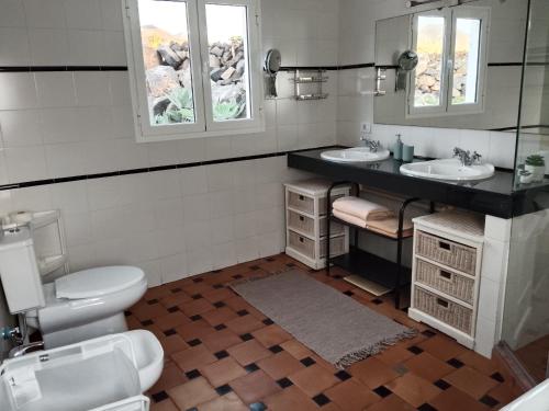 a bathroom with two sinks and a toilet at HelgaHome in Las Breñas