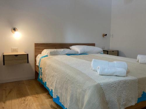 a bedroom with two beds with towels on them at Sa dommu de pedra in Santa Maria Navarrese