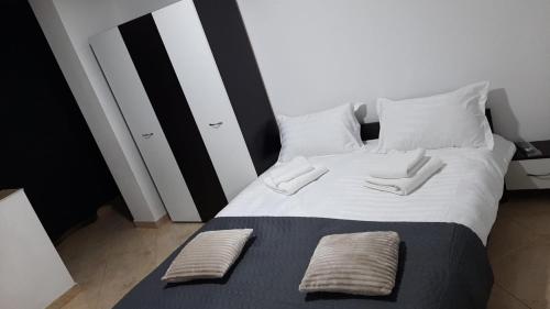 a bedroom with a bed with two pillows on it at White Apartment in Bîrlad