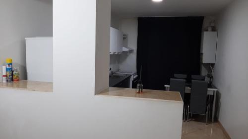 a kitchen with a counter and chairs in a room at White Apartment in Bîrlad