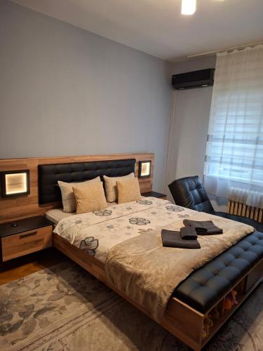 a bedroom with a large bed and a chair at Apartament Sofia in Sofia