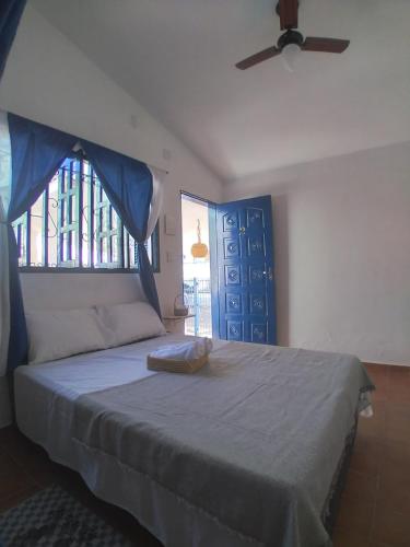 a bedroom with a bed with a ceiling fan and a window at Pousada Nosso Sonho in Natal