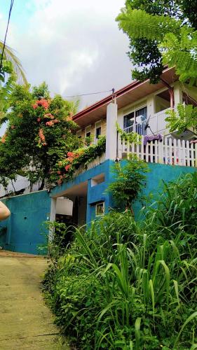 a blue and white house with a white fence at Shalom breaze in Gettapola