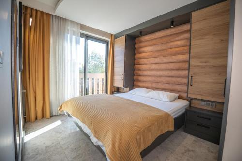 a bedroom with a bed and a large window at Kalender Pansiyon Fethiye in Fethiye