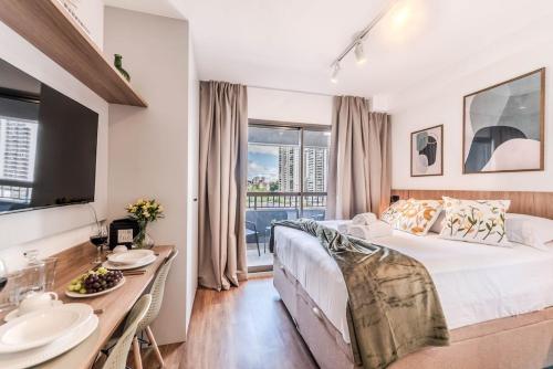 a bedroom with a large bed and a table with plates on it at Studio SP Congonhas, CEIC-Itaú, Expo-SP in São Paulo