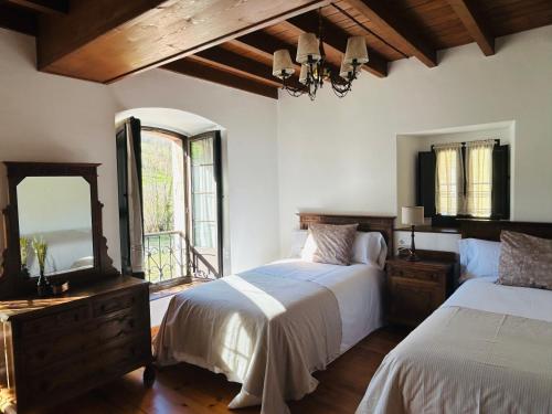 a bedroom with two beds and a large window at Casa Caiceda in Poo de Cabrales