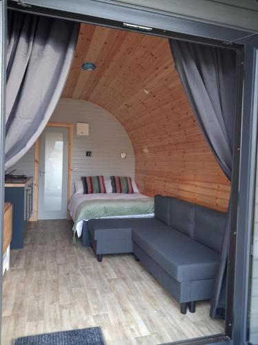 a living room with a couch and a bed at Hilltop Glamping in Ardara