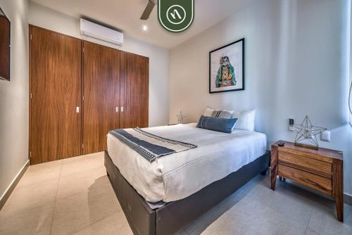 a bedroom with a large bed and a wooden cabinet at 2BR Condo with Rooftop Pool - 2 Min Walk to Beach in Bucerías