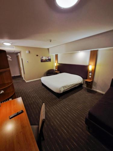 a hotel room with a bed and a desk at Charter Hotel Bournemouth in Bournemouth