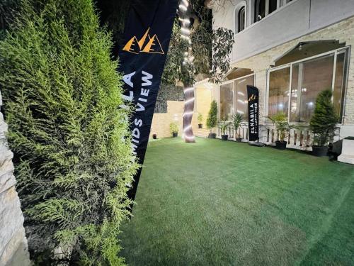 a green lawn in front of a building at El Nabila Front Pyramids & Sphinx View in Cairo
