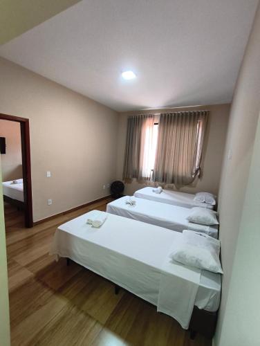 a hotel room with two beds and a mirror at Hotel Colibri Viçosa - Próximo a UFV in Viçosa