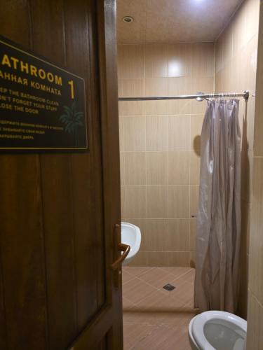 a bathroom with a toilet and a shower curtain at Urban House in Batumi