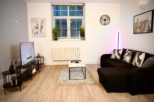 a living room with a couch and a table at Spacious 4BR Apartment 7 Beds Near Station in Newport
