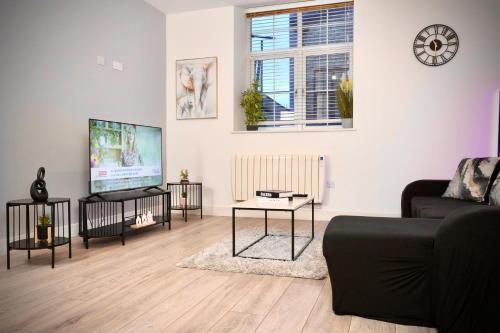 a living room with a couch and a flat screen tv at Spacious 4BR Apartment 7 Beds Near Station in Newport
