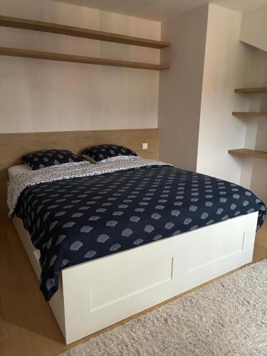 a bedroom with a bed with a blue and white comforter at Studio moderne Arcueil in Arcueil
