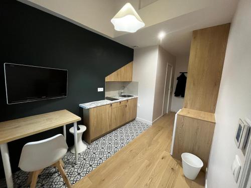 a living room with a desk and a television and a room at Studio moderne Arcueil in Arcueil