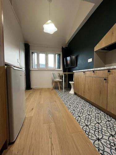 Studio moderne Arcueil في آركويي: مطبخ فارغ مزود بثلاجة وطاولة
