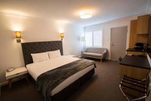 una camera d'albergo con letto e sedia di Quays Hotel a Batemans Bay