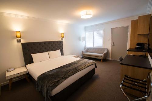 a hotel room with a bed and a chair at Quays Hotel in Batemans Bay