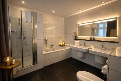 a bathroom with two sinks and a shower at Hotel Bayrischer Hof in Heidelberg