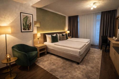 a hotel room with a bed and a chair at Hotel Bayrischer Hof in Heidelberg