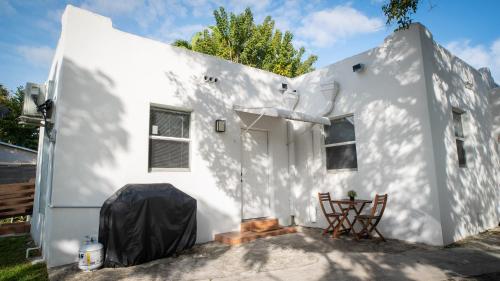 a white house with two chairs in front of it at Stylish Studio Near Wynwood & Design District in Miami
