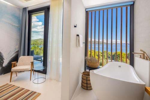 a bathroom with a tub and a large window at Villa Pirata in Jezera