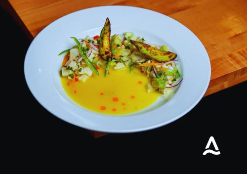 a white plate with a dish of food on a table at Almasur Express Punta Arenas in Punta Arenas
