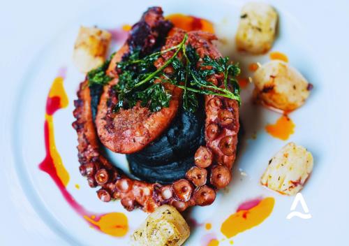 a plate of food with meat and vegetables on it at Almasur Express Punta Arenas in Punta Arenas
