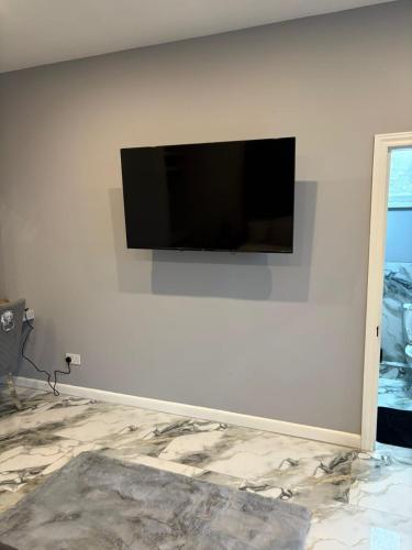 a flat screen tv hanging on a white wall at The Norwich Hideaway - Private Hot Tub in Norwich