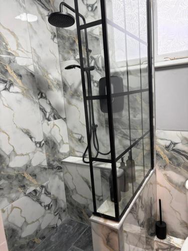 a shower in a bathroom with a marble wall at The Norwich Hideaway - Private Hot Tub in Norwich