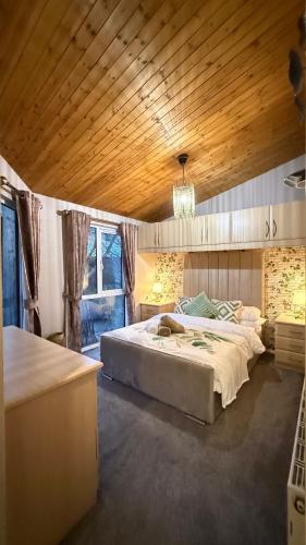 a bedroom with two beds and a wooden ceiling at Cheerful 3 bedroom Lodge At White cross Bay Windermere in Windermere