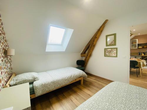a bedroom with two beds and a stair case at Le Grand Francillon in Villebarou