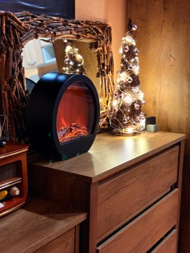 a fireplace on top of a dresser with a christmas tree at Cozy Studio Apartment Pale in Pale