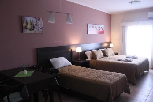 a hotel room with two beds and a table at Antares Apartments in Campana