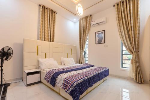 a bedroom with a bed and a large window at Buddy's Court Luxury 5Bedroom,3 & 2bed Apartment in Ikeja