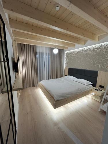 a bedroom with a large bed and a desk at Sol Chalet Maramures in Borşa