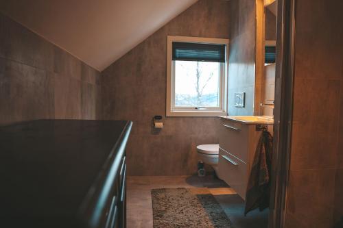 ein Badezimmer mit Toilette und Fenster in der Unterkunft Solyun in Hol