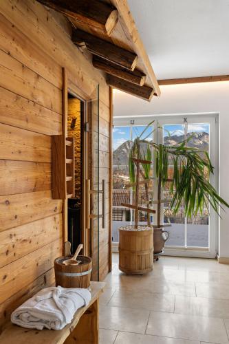a room with wooden walls and a large window at Hotel Bergsonne Allgäu in Sonthofen