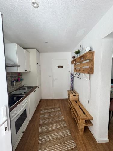 a small kitchen with white cabinets and a sink at Mimos Ferienhaus in Meißendorf