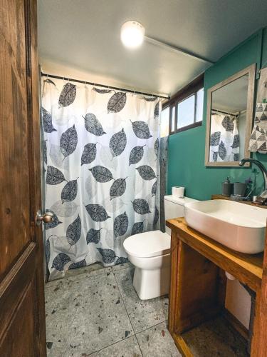a bathroom with a sink and a toilet and a shower curtain at Tiny House 3 En el río in Linares